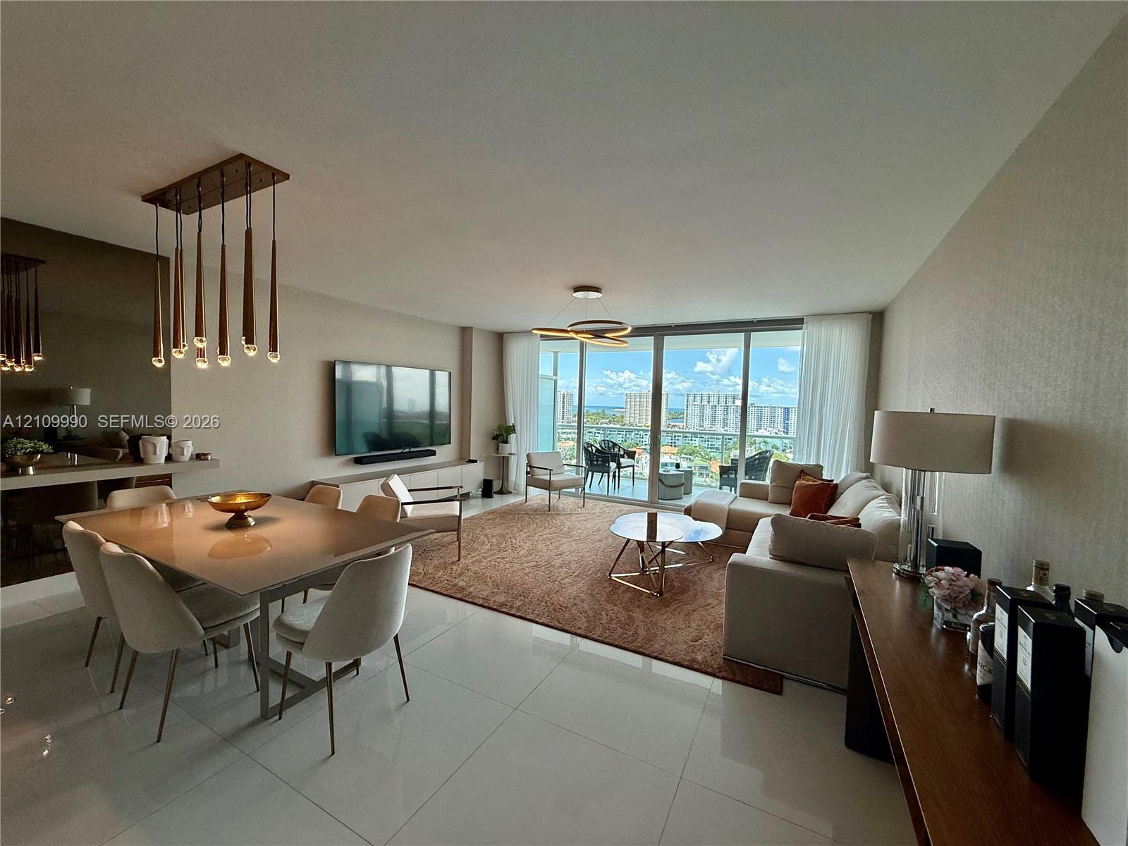 Large-format polished tile flooring, floor-to-ceiling glass sliding doors, modern multi-pendant dining chandelier, and geometric ceiling lighting fixture