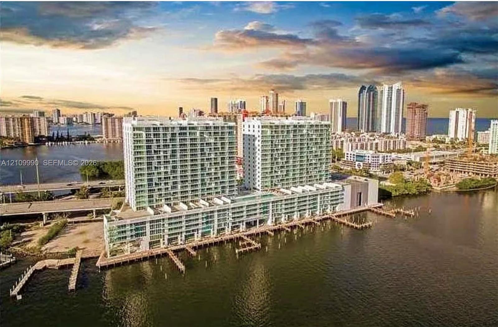 Waterfront high-rise building featuring extensive glass balconies, integrated boat slips, and deep-water access