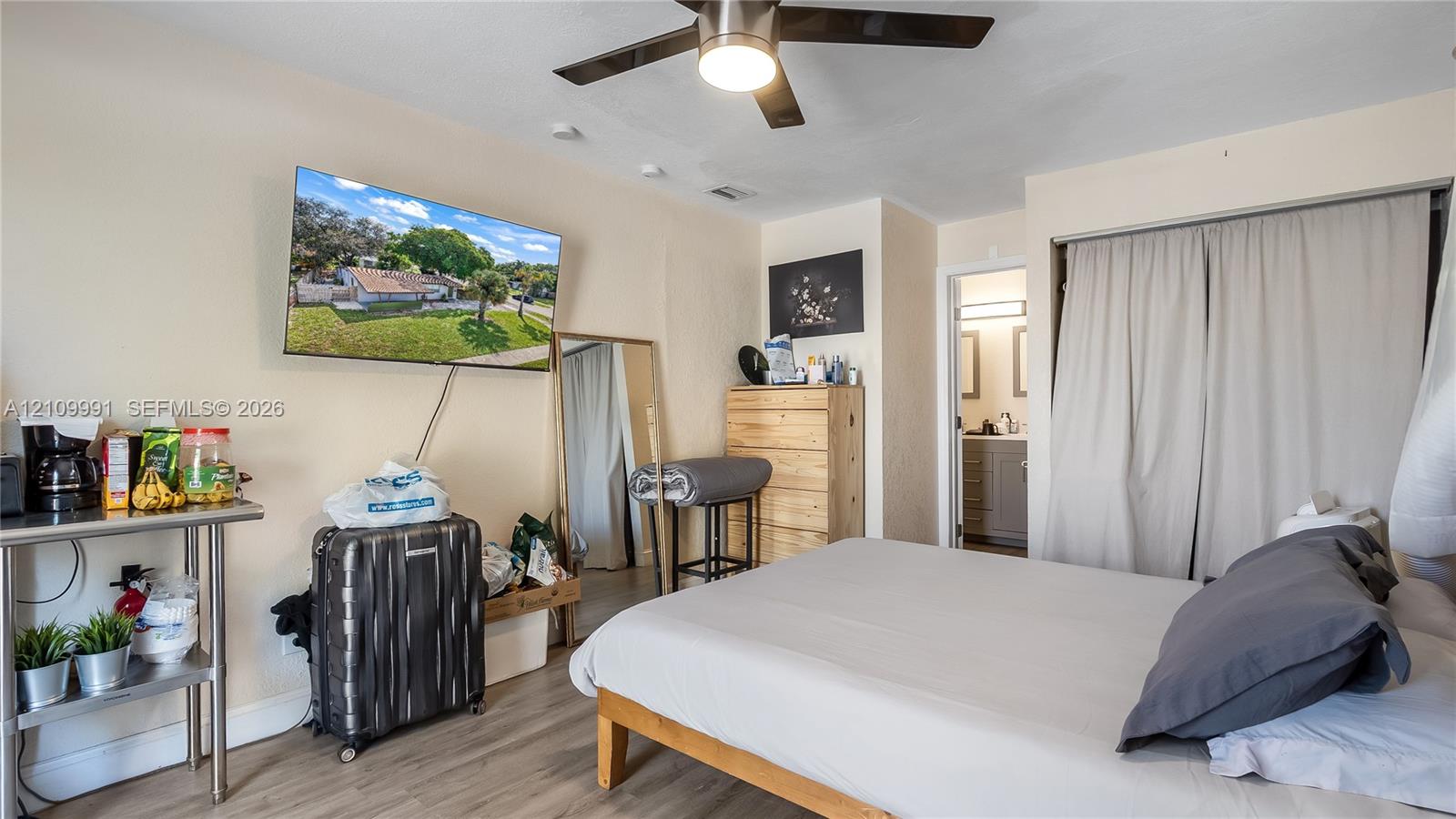 Interior room featuring wood-finish flooring, a ceiling fan with integrated lighting, and a closet with sliding panel doors