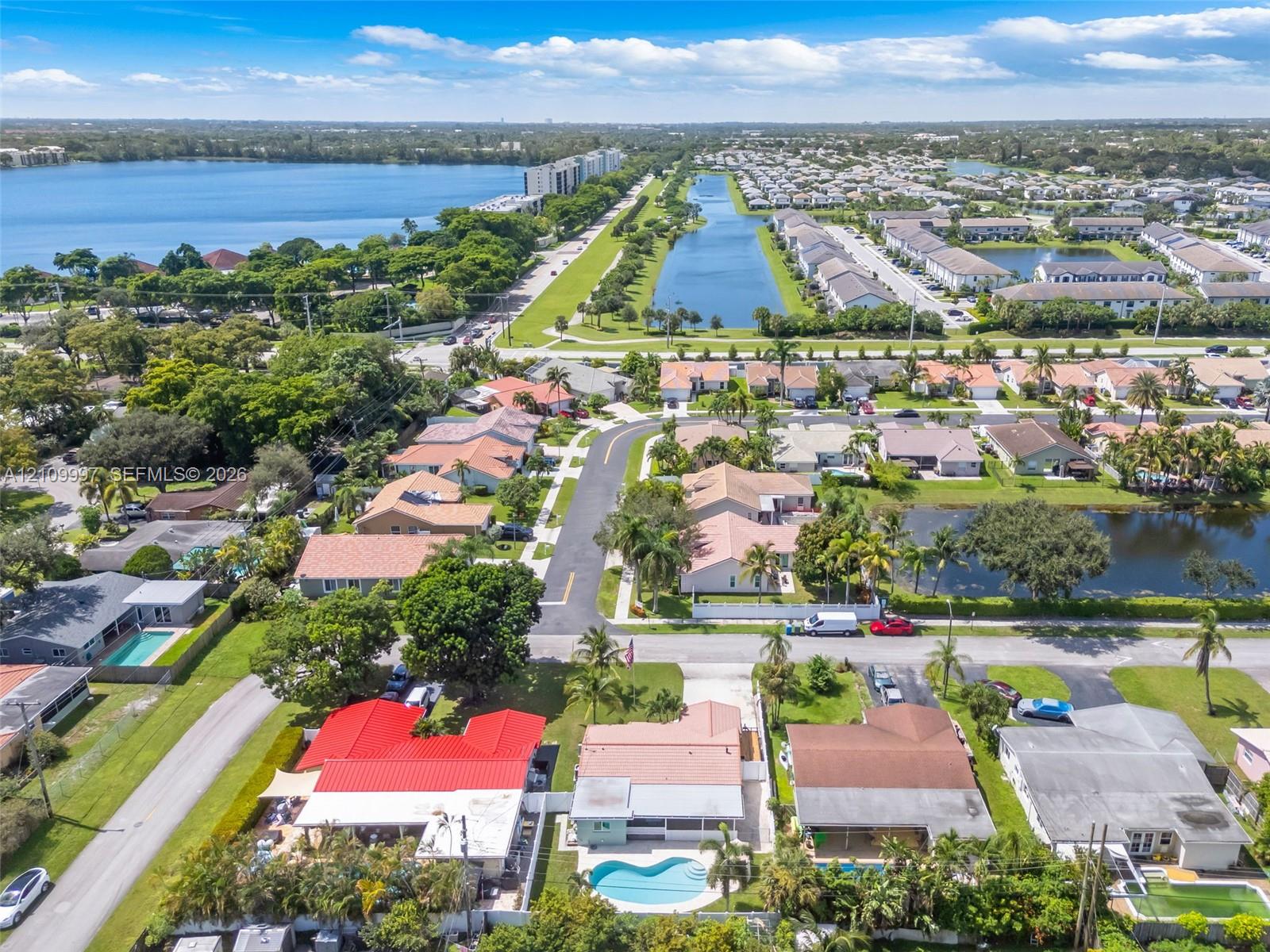 Aerial perspective featuring a residential property with a private in-ground swimming pool, fenced perimeter, and tiled roof