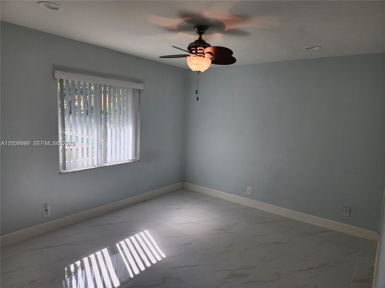 Interior room featuring large-format tile flooring, recessed lighting, and a ceiling fan with integrated light fixture