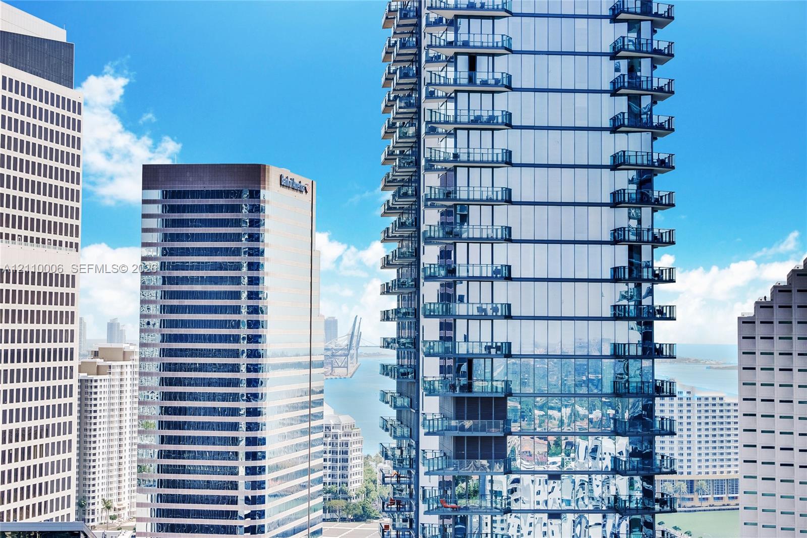 High-rise tower featuring glass curtain wall construction and stacked private balconies
