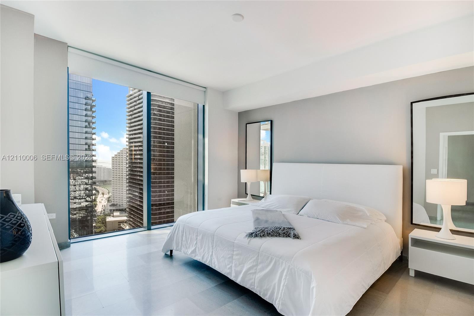 Floor-to-ceiling windows, polished stone flooring, and urban skyline exterior