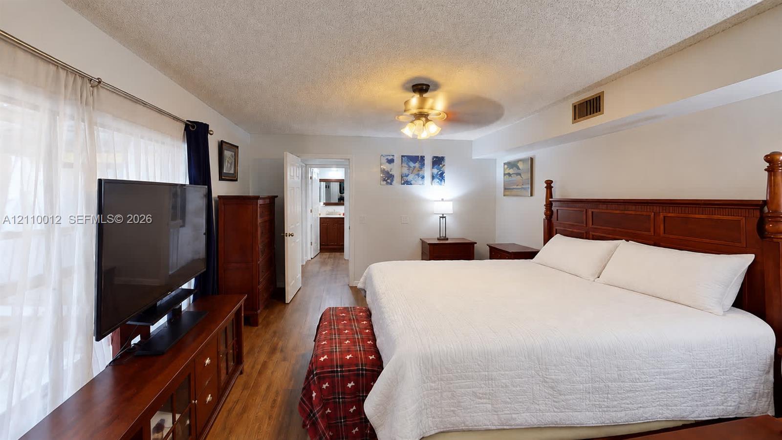 Interior room featuring wood-finish flooring and a central ceiling fan with integrated lighting