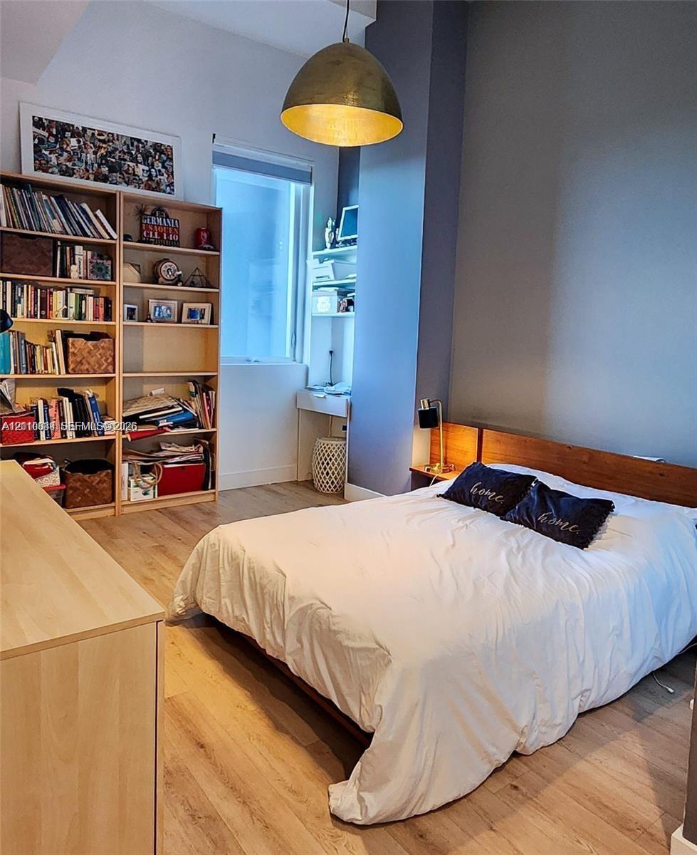 Wood-finish flooring, dome-style pendant lighting, built-in shelving, and a custom wood headboard