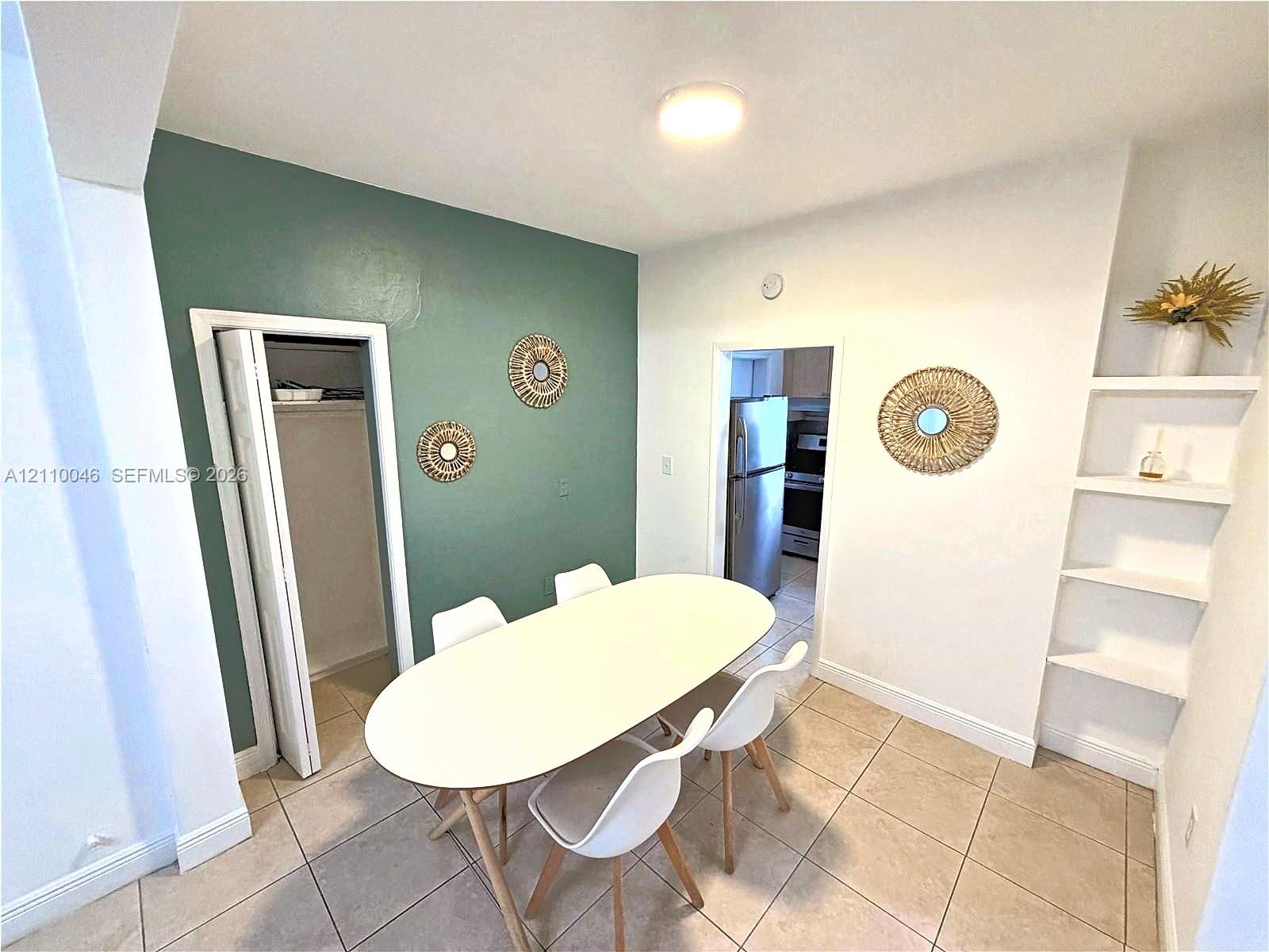 Ceramic tile flooring, accent wall, built-in recessed shelving, and a reach-in closet with bi-fold doors