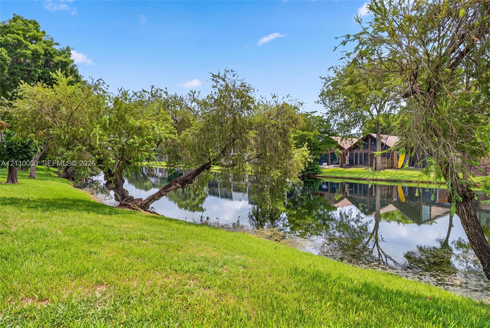 Waterfront parcel featuring a manicured lawn, mature trees, and direct water access