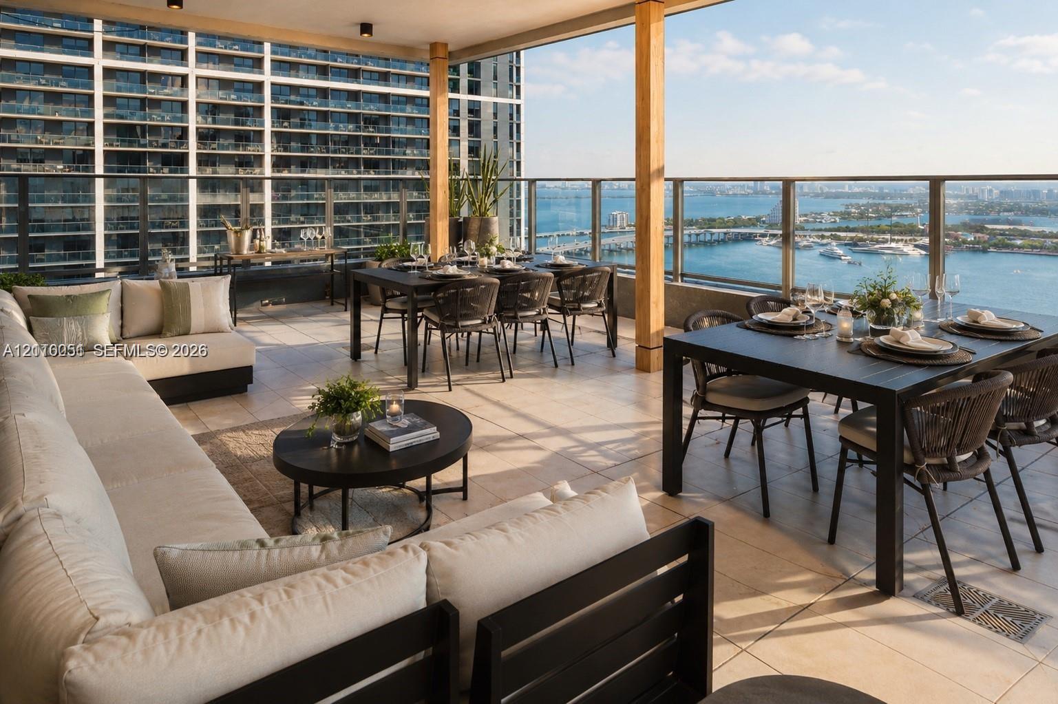 Covered outdoor terrace featuring large-format stone tile flooring, a glass and metal railing system, and recessed overhead lighting