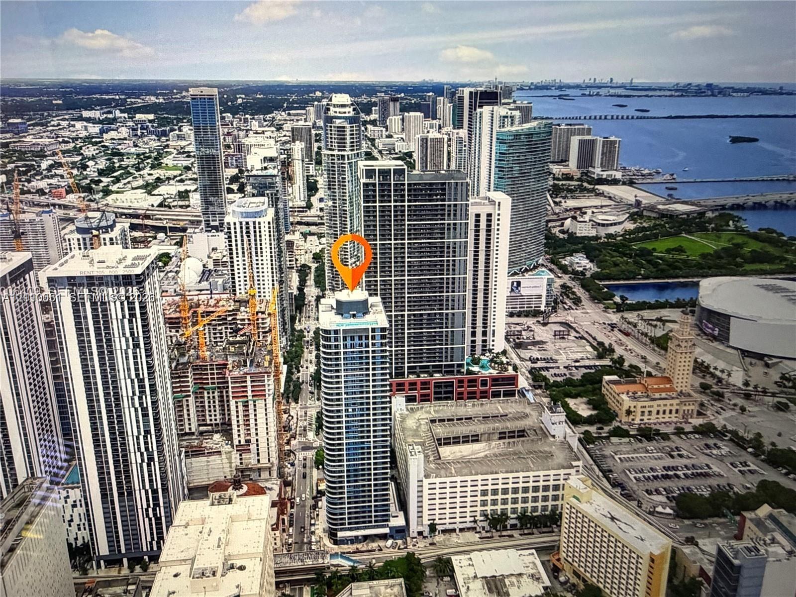 High-rise tower featuring a glass facade, expansive urban scenery, and water frontage