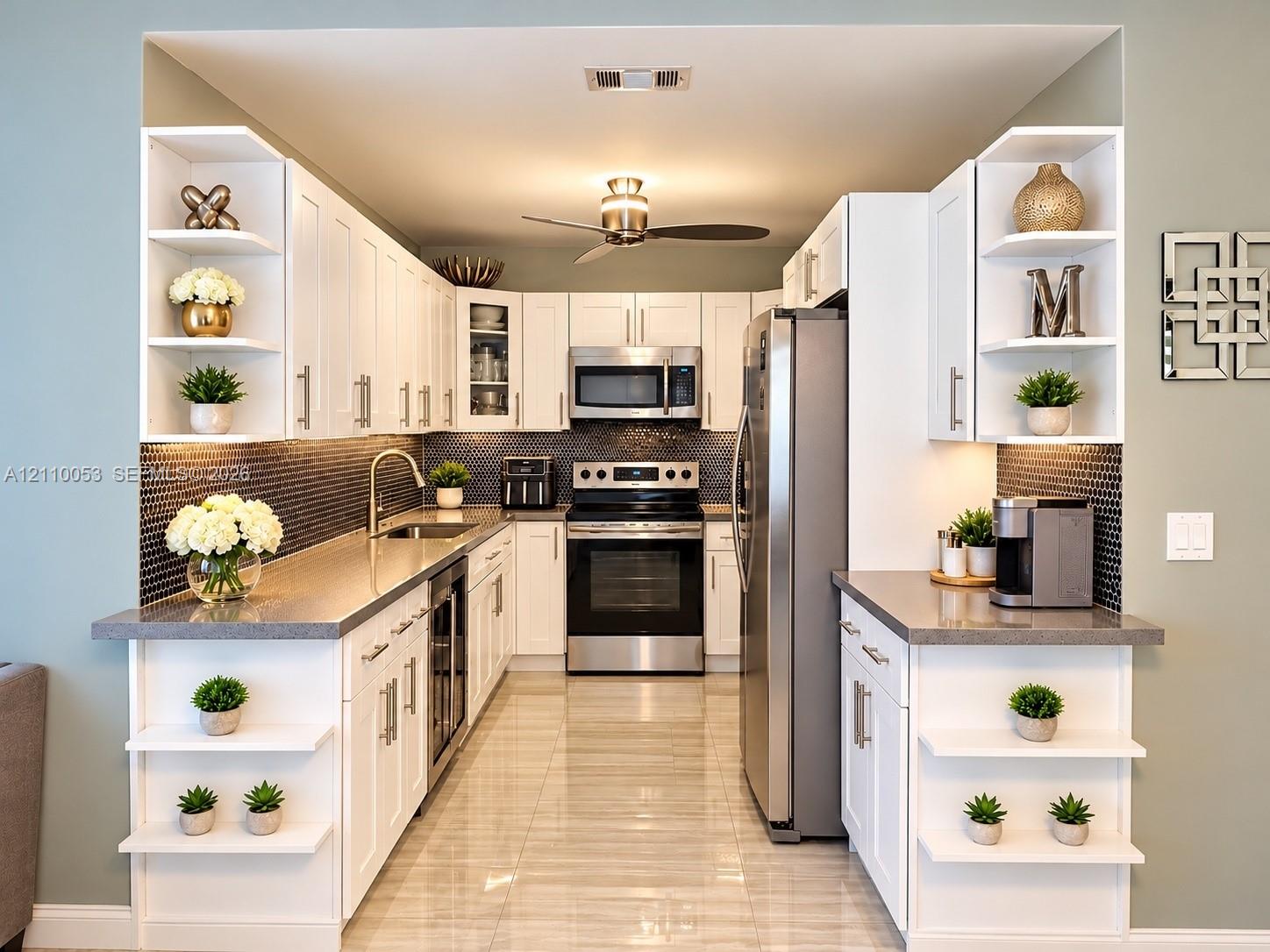 Kitchen featuring white shaker-style cabinetry, dark hexagonal tile backsplash, stone-finish countertops, stainless steel appliances, and integrated display shelving