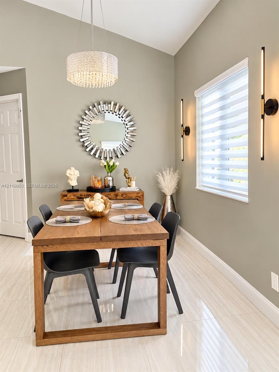 Vaulted ceilings, large-format tile flooring, drum-style chandelier, and vertical matte black wall sconces
