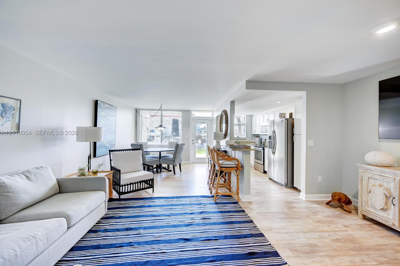 Open concept floor plan featuring recessed lighting, light wood-finish flooring, a kitchen breakfast bar, and stainless steel appliances