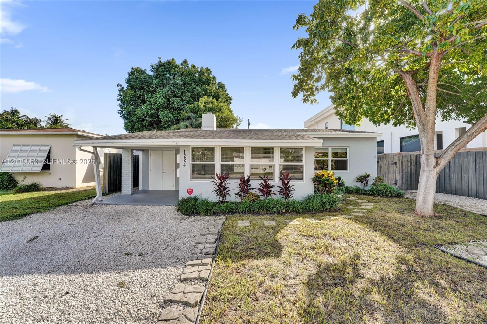 Single-story residence featuring a low-slope roof, light-colored stucco exterior, covered entryway, and stone paver accents throughout the landscaped yard Single-story residence featuring a low-slope roof, light-colored stucco exterior, covered entryway, and stone paver accents throughout the landscaped yard