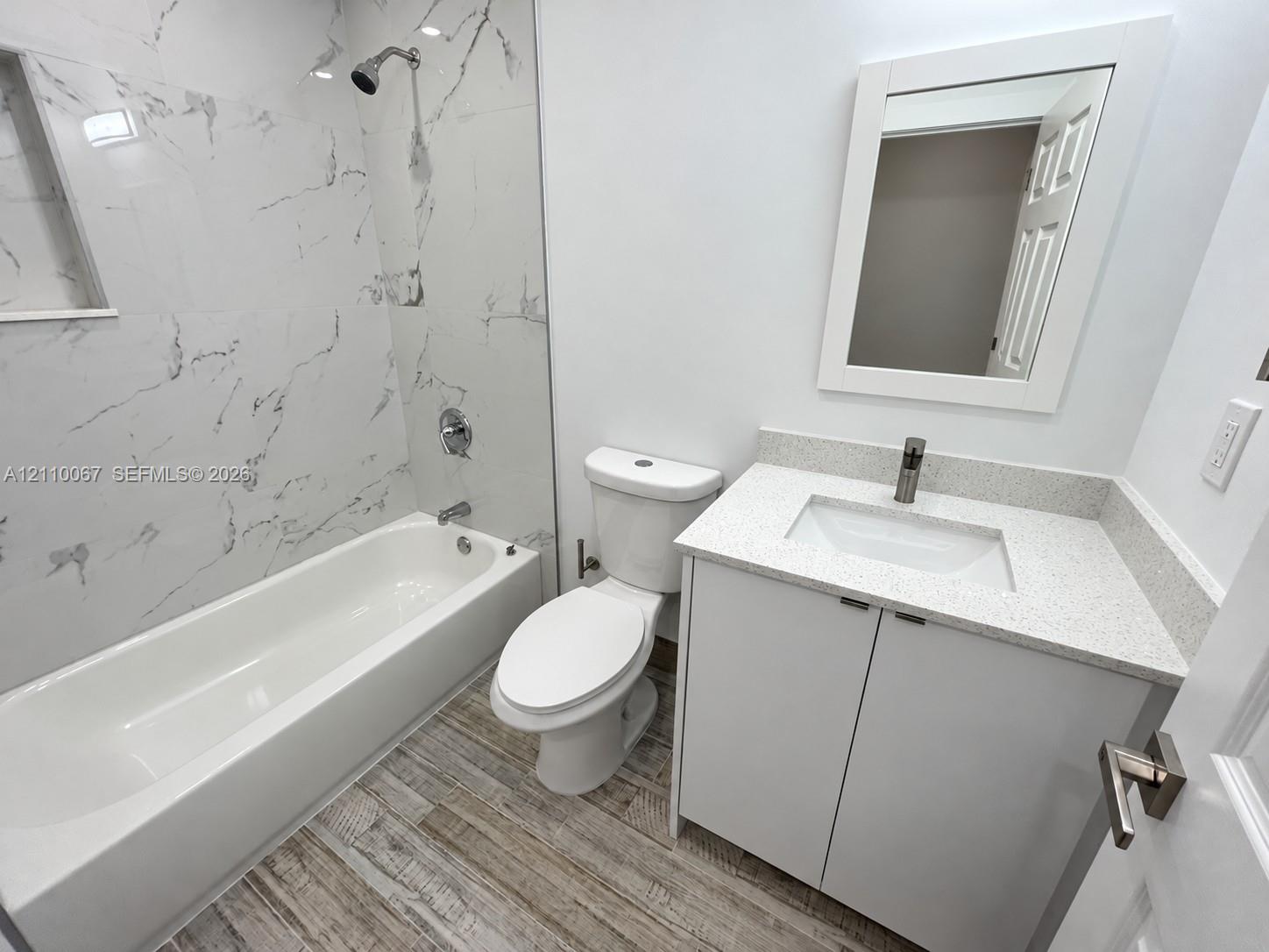 Open interior space featuring polished stone-finish flooring with veining, recessed lighting, neutral wall paint, and glass-paneled double doors