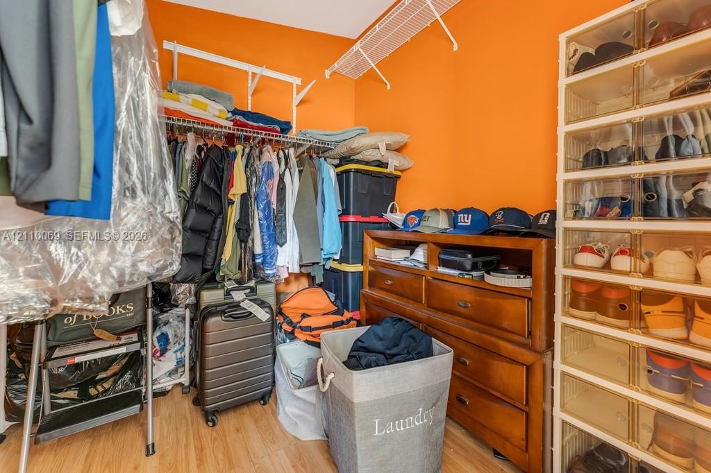 Storage area featuring wood-finish flooring and tiered wire shelving