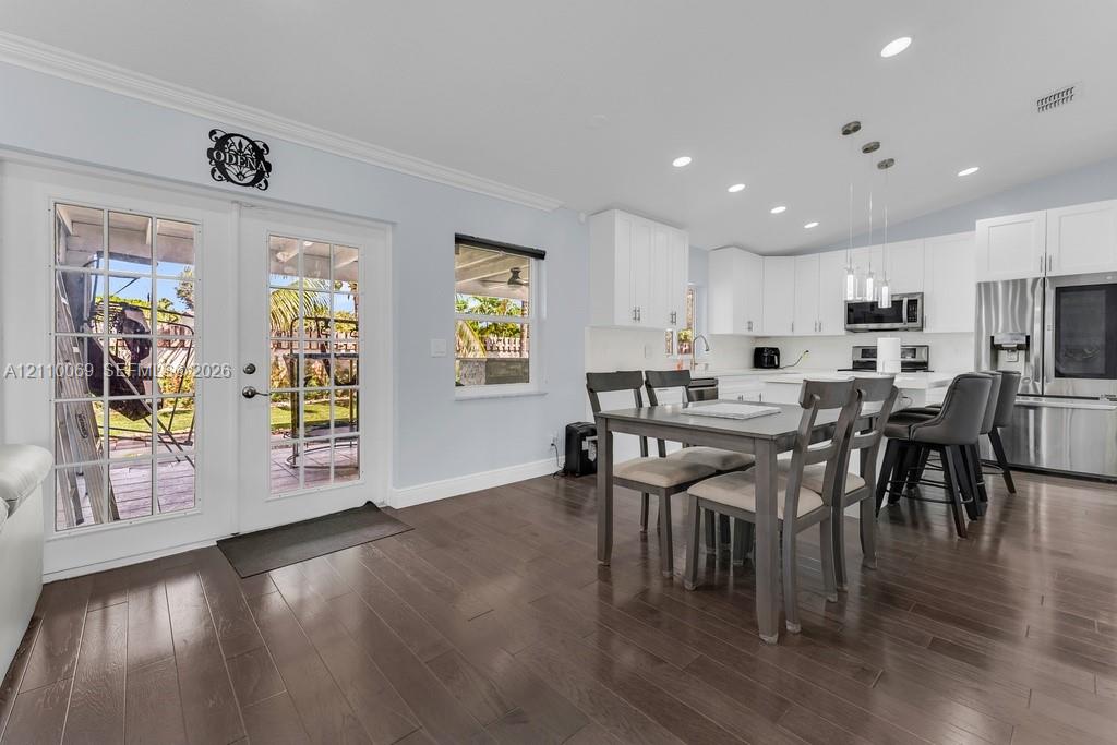 Kitchen featuring white shaker cabinetry, stainless steel appliances, recessed lighting, and wood-finish flooring with dual-pane French doors