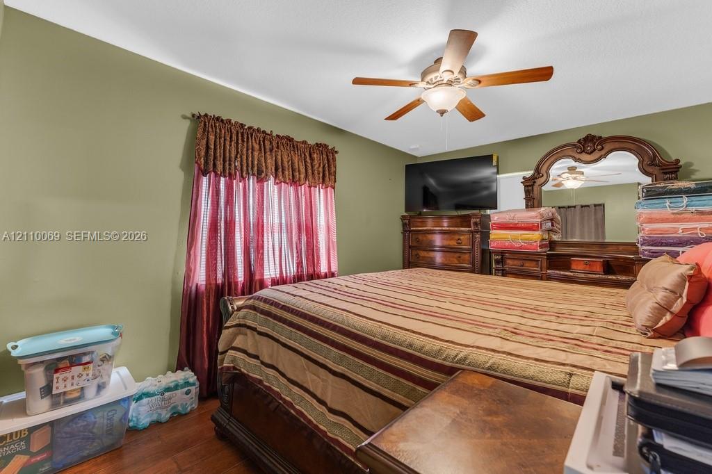 Room featuring wood-finish flooring and a central ceiling fan with integrated lighting