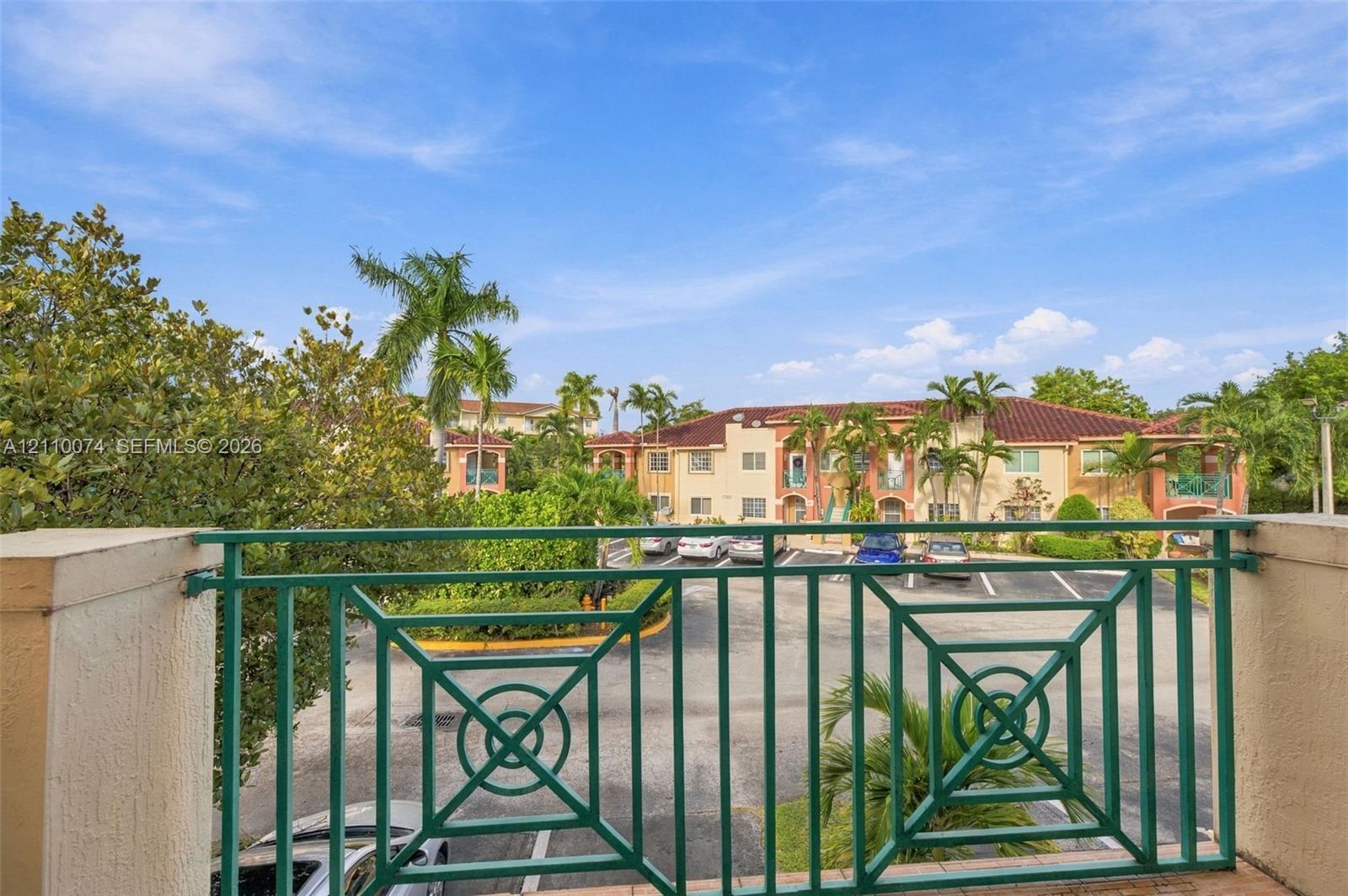 Balcony featuring green metal railing, stucco pillars, and tile flooring