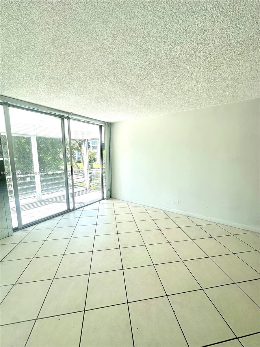 Living area featuring floor-to-ceiling sliding glass doors and ceramic tile flooring