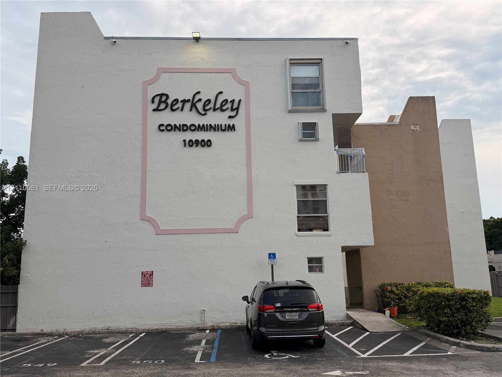 Exterior facade featuring a stucco finish, multi-level building design, dedicated parking stalls, and paved access ramp Exterior facade featuring a stucco finish, multi-level building design, dedicated parking stalls, and paved access ramp