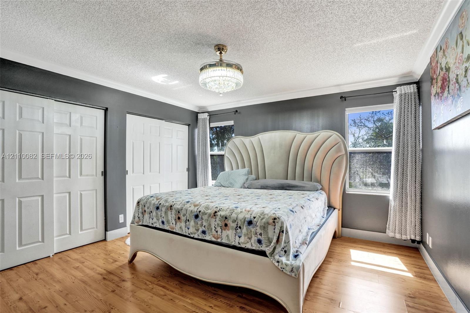 Wood-finish flooring, crystal-accented chandelier fixture, dual pane windows, and multi-panel closet doors