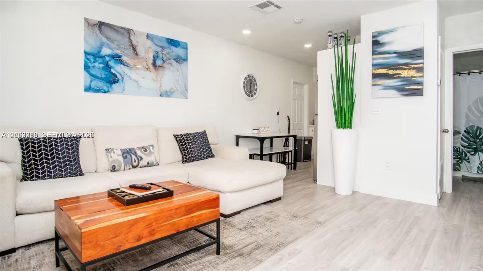 Neutral interior featuring wood-finish flooring, recessed lighting, and crisp white walls