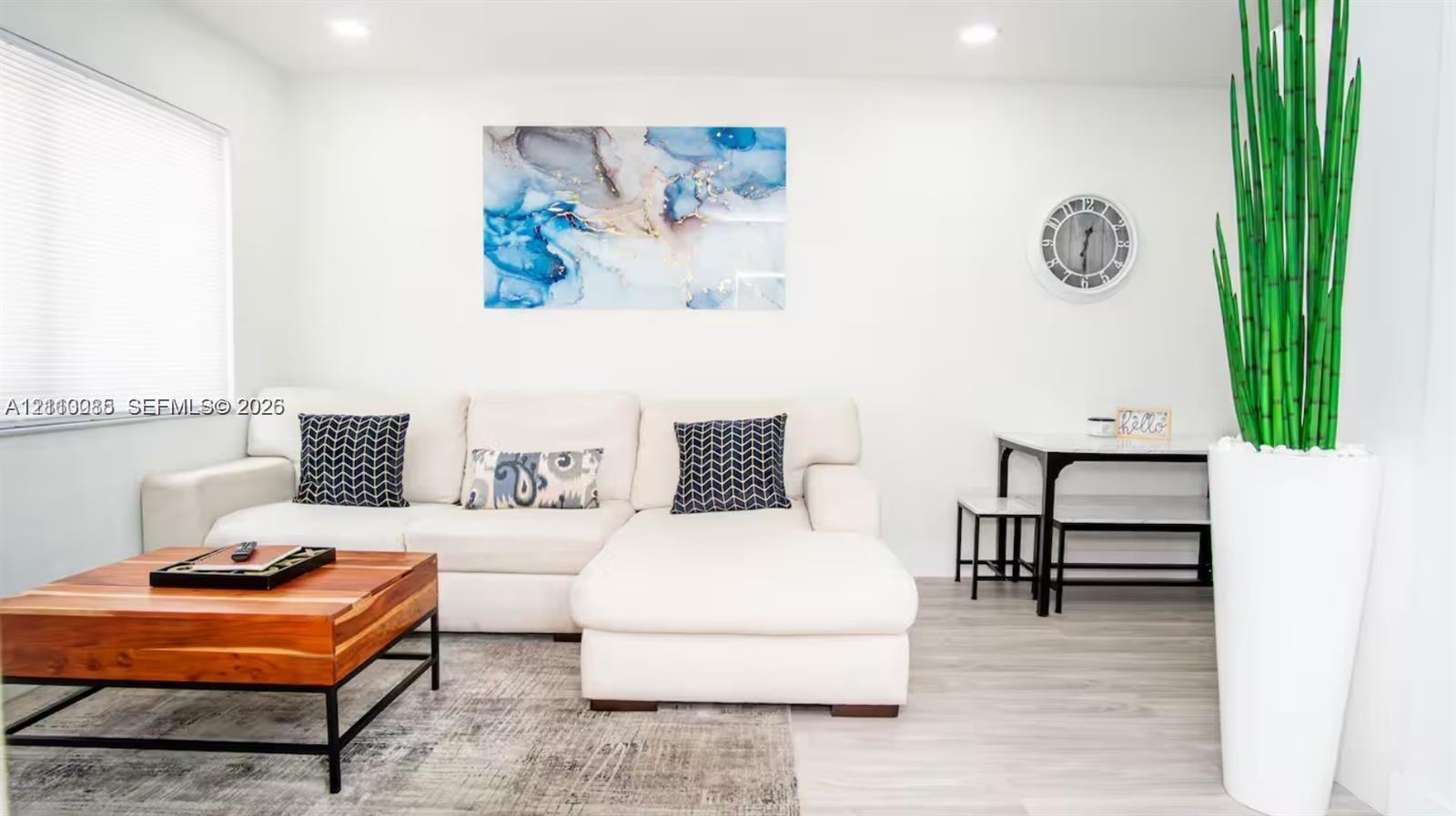 Neutral-toned interior featuring wood-finish flooring, recessed lighting, and horizontal window blinds