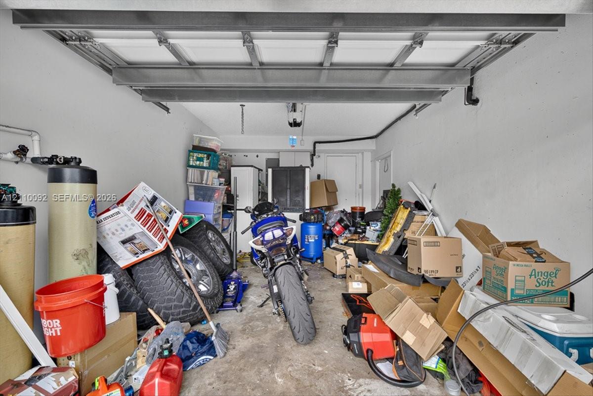 Enclosed garage featuring an overhead door mechanism and installed water treatment system