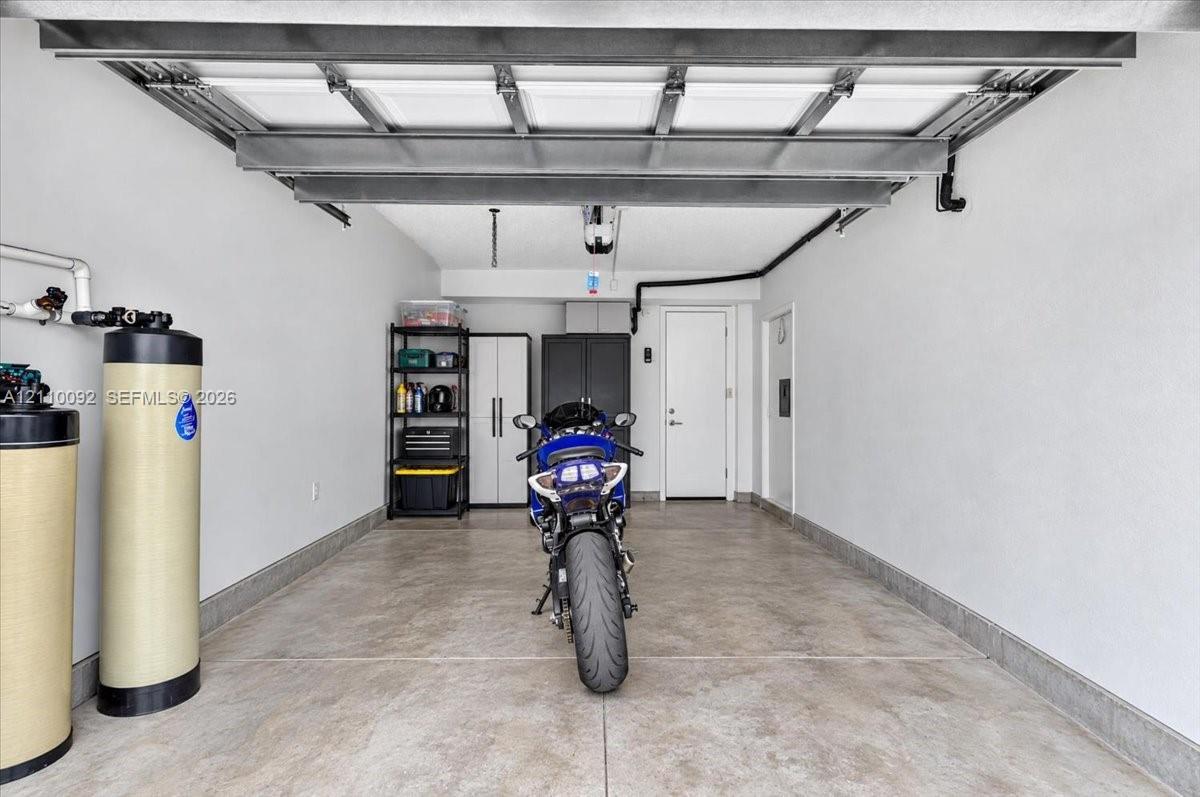 Garage featuring concrete flooring, interior walls with a neutral finish, and a dedicated water filtration system