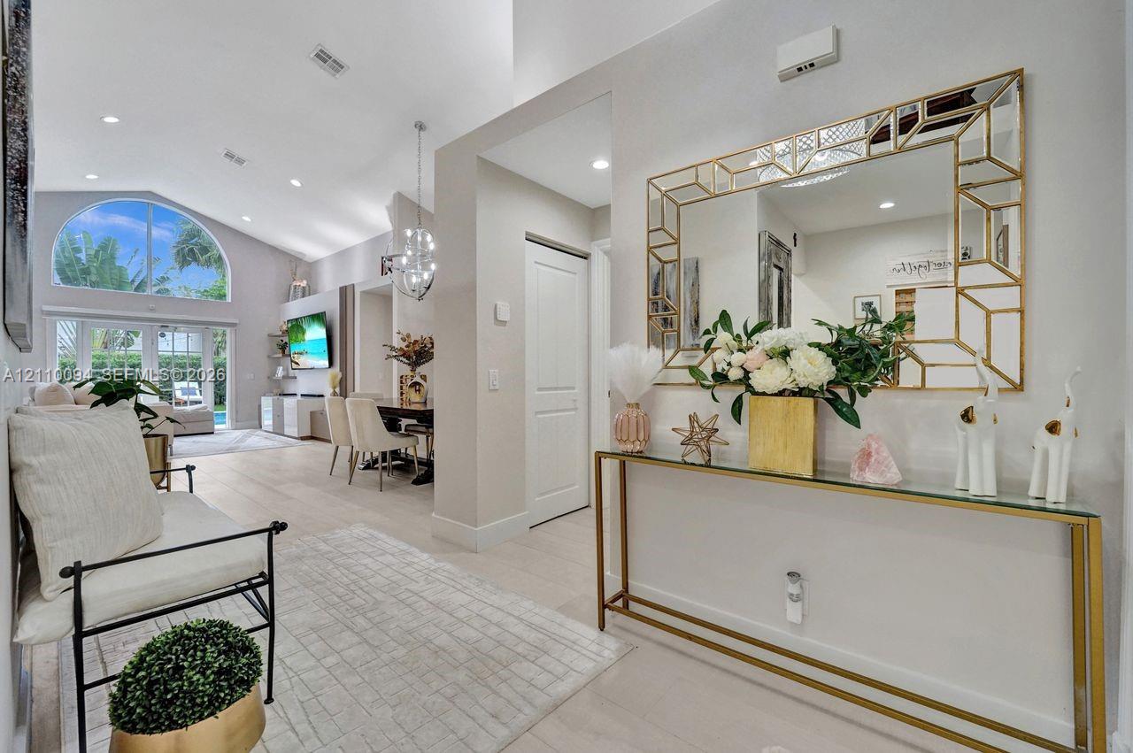 Vaulted ceiling featuring recessed lighting and a large arched window with glass-paned double doors Vaulted ceiling featuring recessed lighting and a large arched window with glass-paned double doors