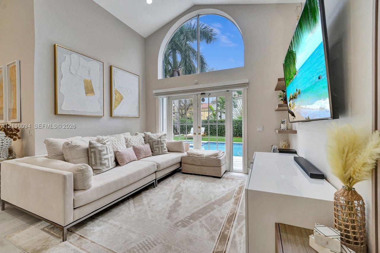 Vaulted ceilings, arched transom window, French glass doors, and built-in floating shelving