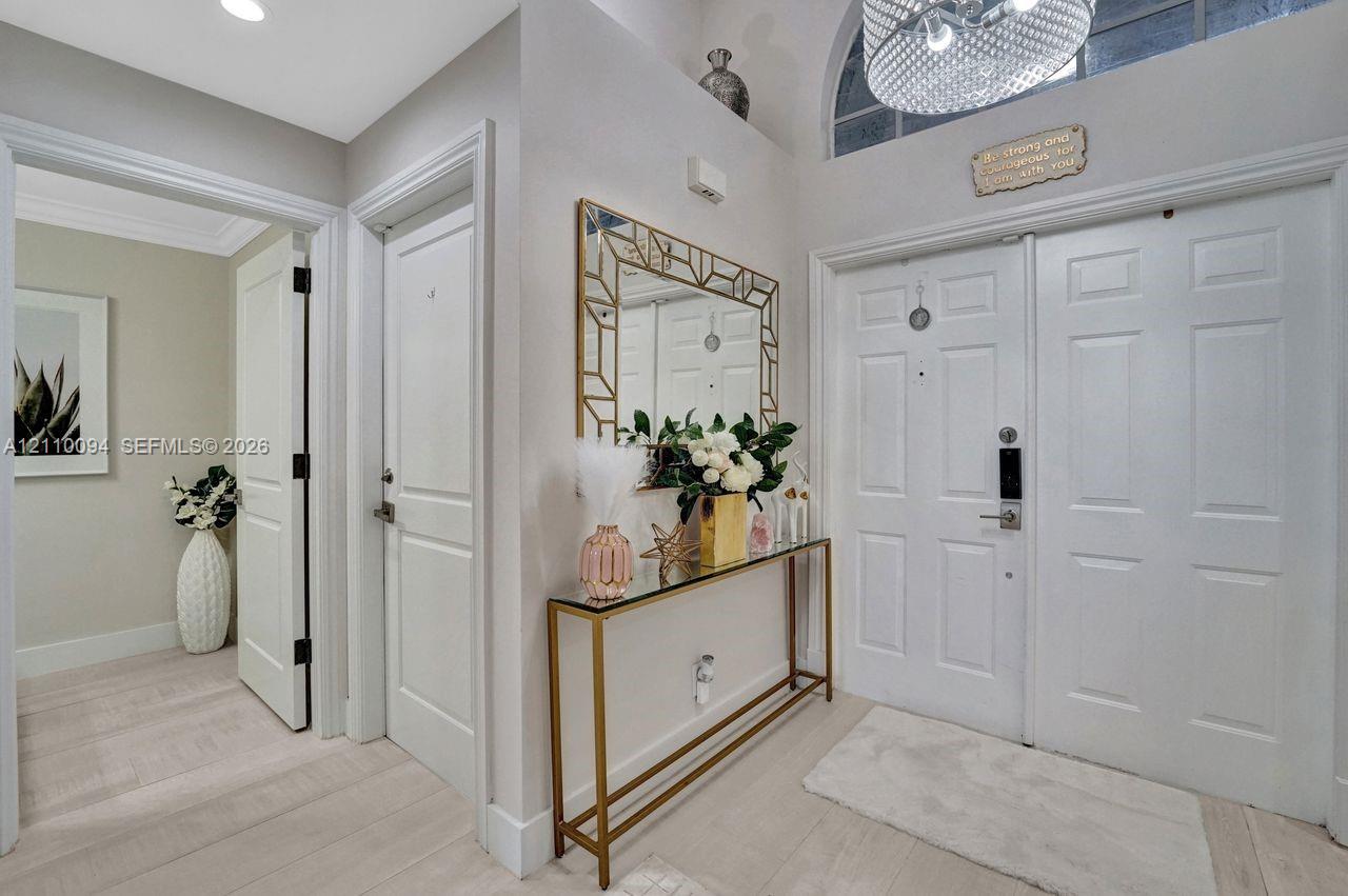 Entryway featuring double-door entry, arched transom window, recessed lighting, chandelier, and light-toned wood-finish flooring