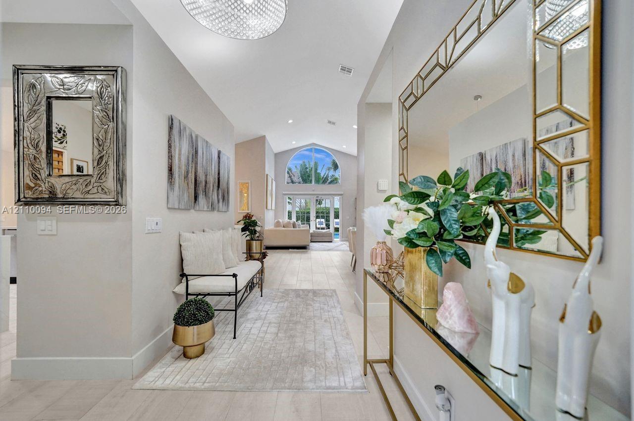 Vaulted ceilings, large arched transom window, and light-toned wood-finish flooring Vaulted ceilings, large arched transom window, and light-toned wood-finish flooring