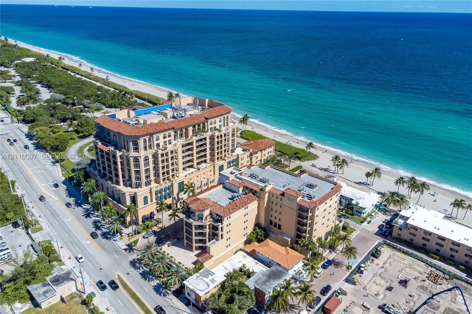 High-rise coastal property featuring Mediterranean-inspired architectural design, terracotta tile roofing, multi-level balconies, and a direct beachfront location High-rise coastal property featuring Mediterranean-inspired architectural design, terracotta tile roofing, multi-level balconies, and a direct beachfront location