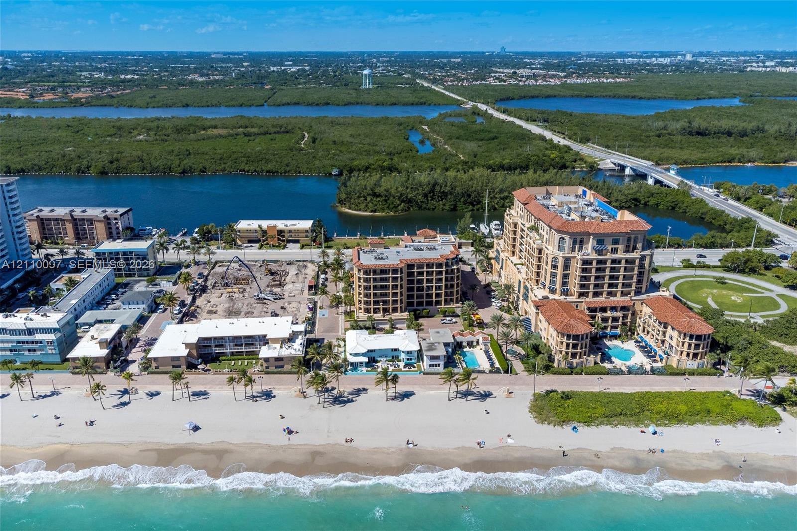 Aerial perspective of beachfront property featuring direct ocean access, building-integrated swimming pools, terracotta-style roofing, and multi-level balconies Aerial perspective of beachfront property featuring direct ocean access, building-integrated swimming pools, terracotta-style roofing, and multi-level balconies