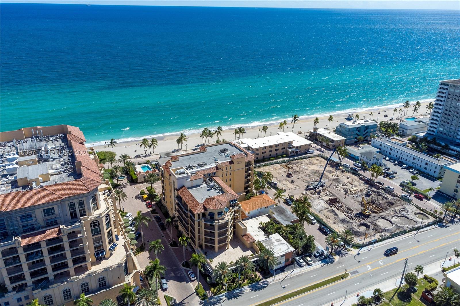 Coastal aerial perspective featuring proximity to the shoreline, multi-story masonry construction, clay tile roofing, and mature palm landscaping Coastal aerial perspective featuring proximity to the shoreline, multi-story masonry construction, clay tile roofing, and mature palm landscaping