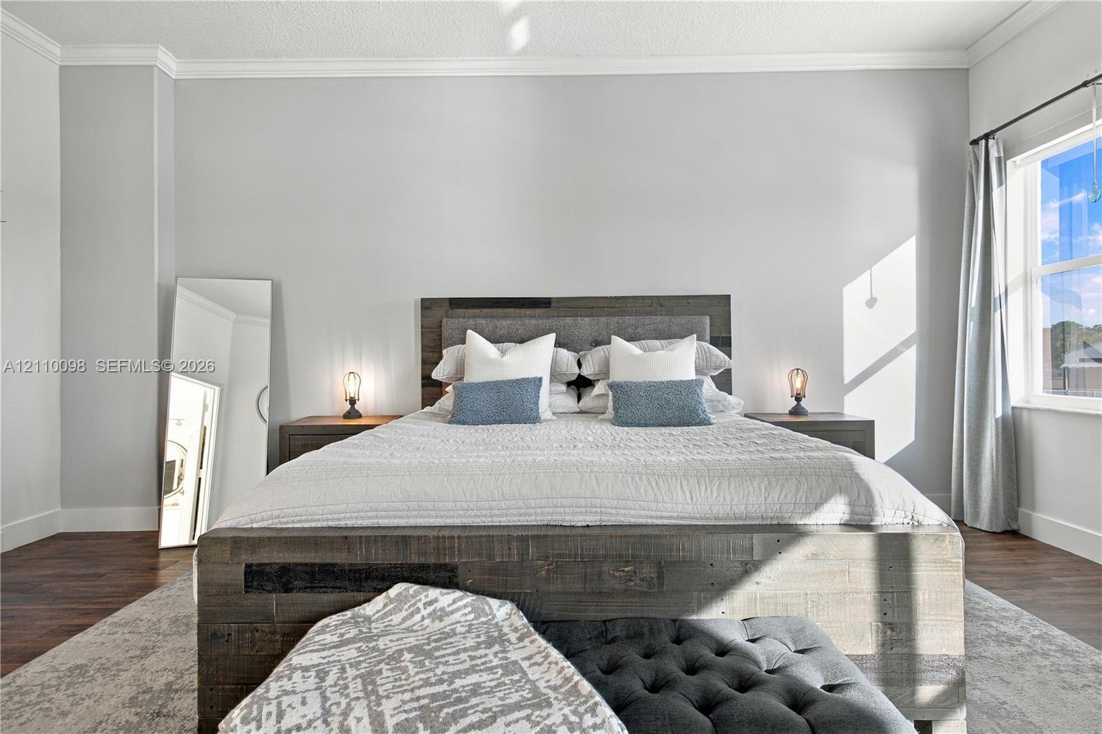 Neutral-toned wall paint, wood-finish flooring, and crown molding