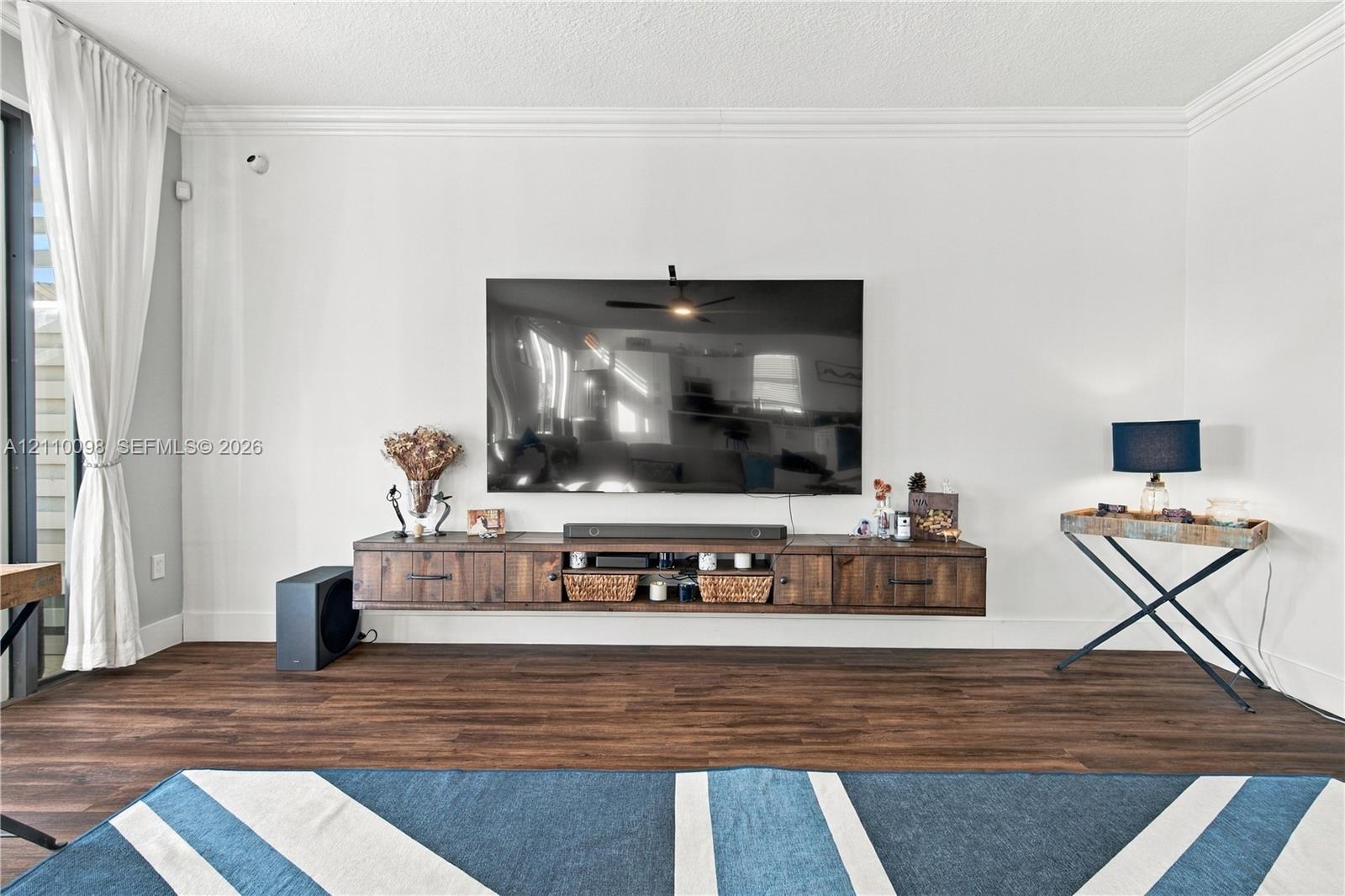 Wall-mounted wood-finish media console, crown molding, and wood-finish flooring