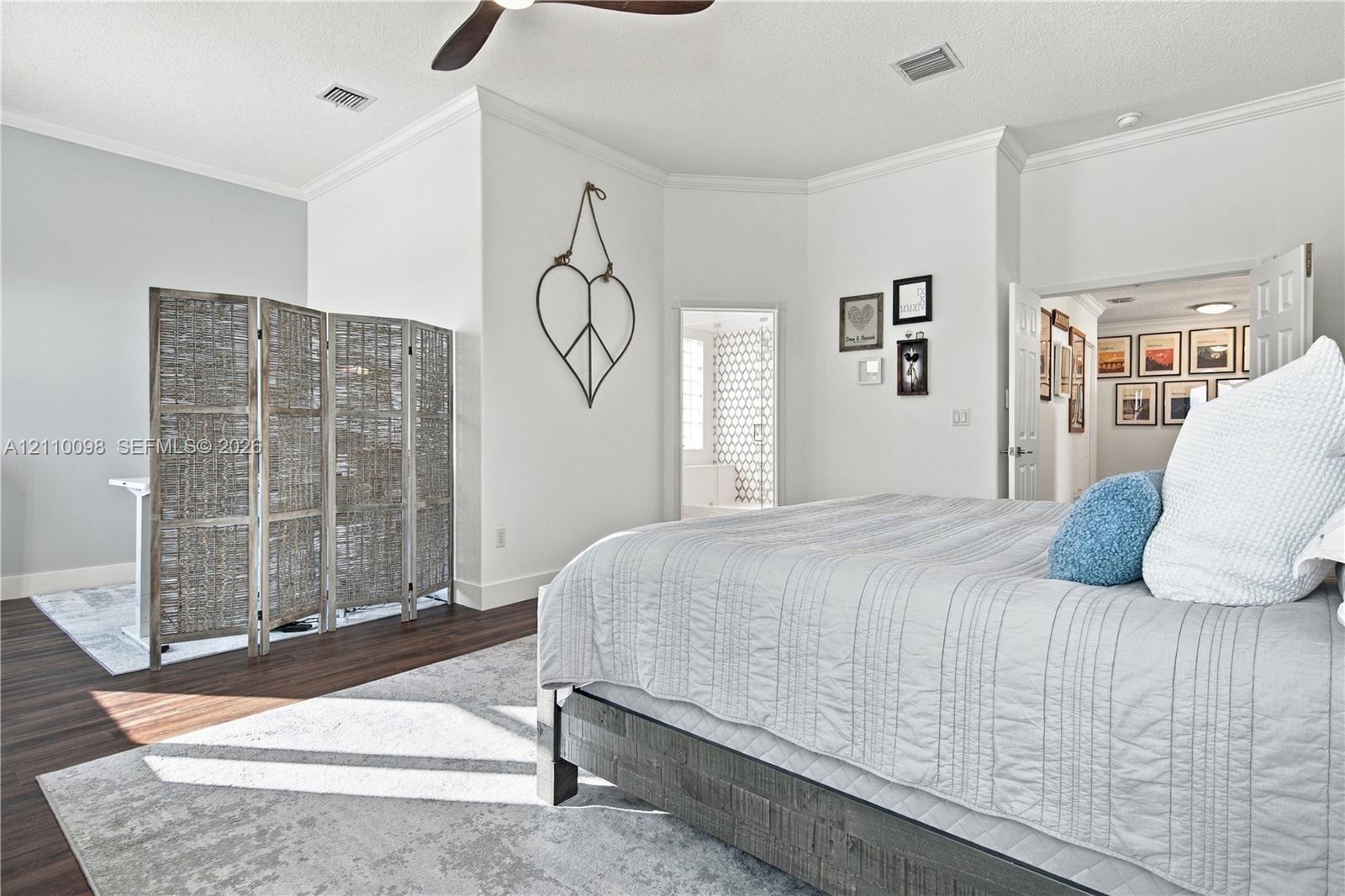 Wood-finish flooring, crown molding, and ceiling fan with integrated lighting