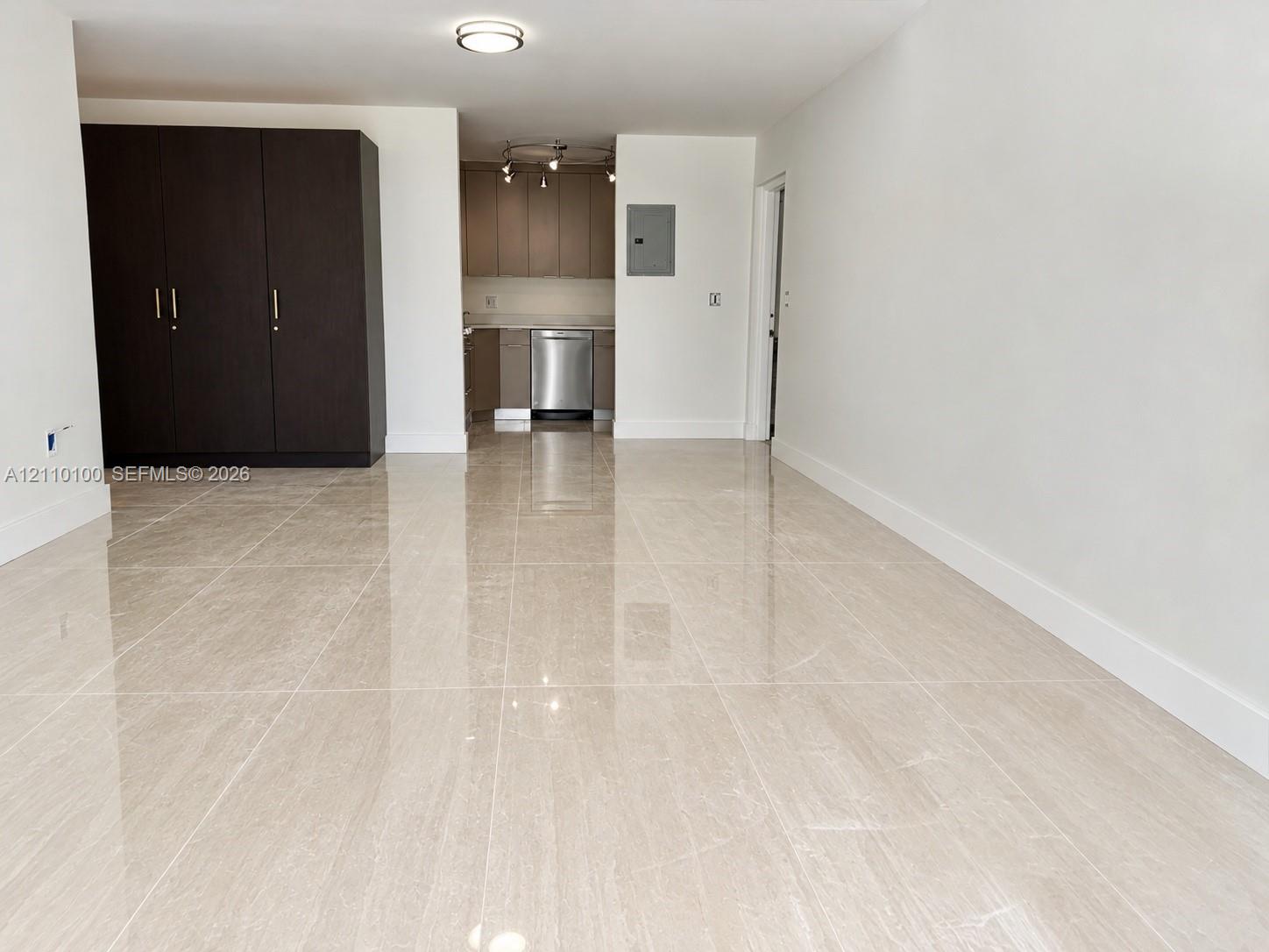 Large-format polished tile flooring, dark-toned built-in cabinetry, and neutral wall finishes Large-format polished tile flooring, dark-toned built-in cabinetry, and neutral wall finishes