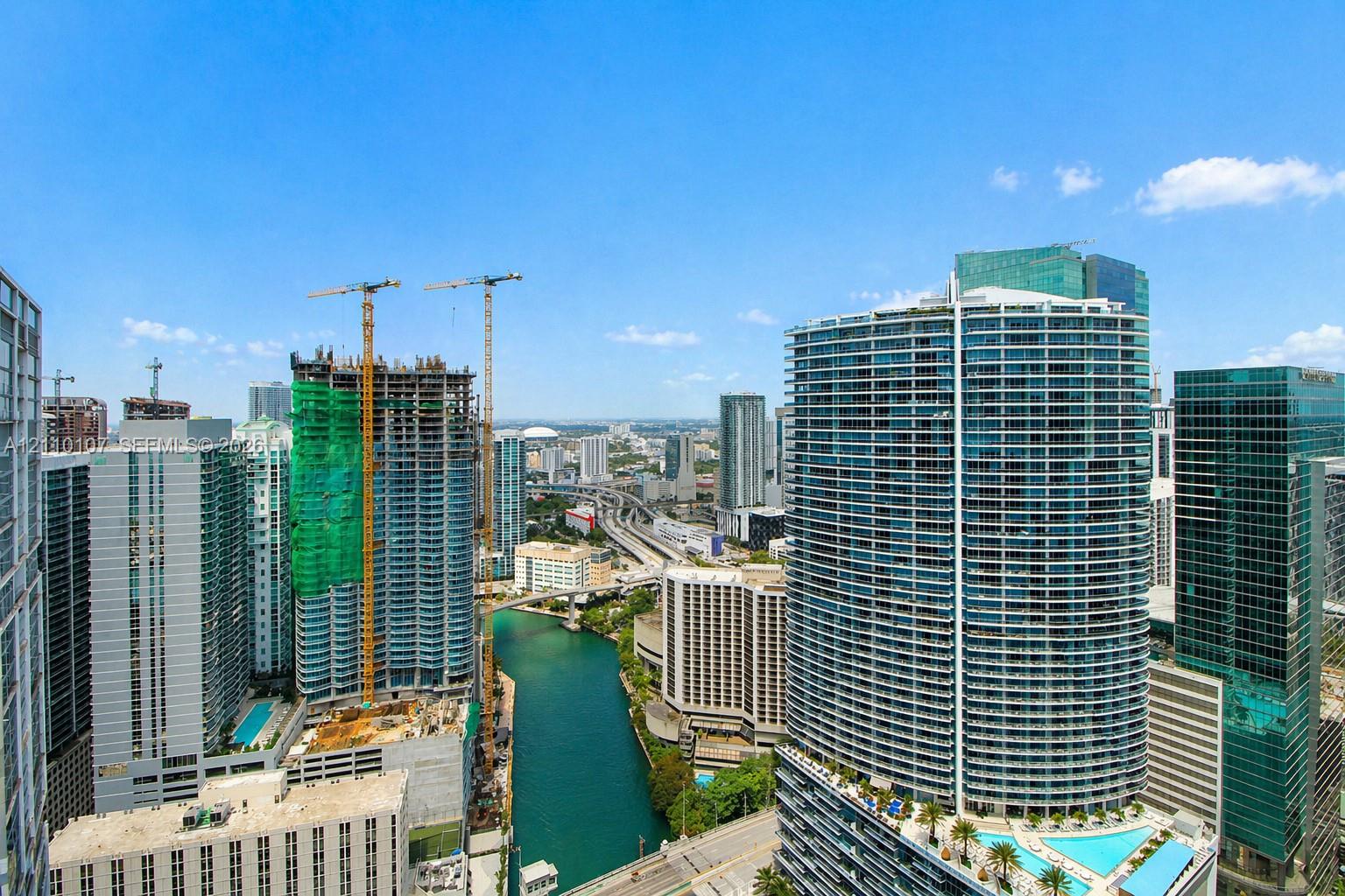 High-rise urban landscape featuring a waterway, multi-story glass-facade towers, and structured infrastructure High-rise urban landscape featuring a waterway, multi-story glass-facade towers, and structured infrastructure