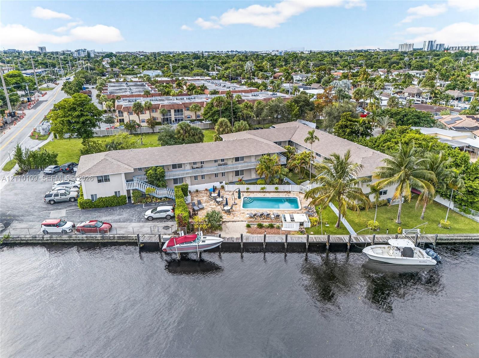 Waterfront property featuring a private swimming pool, concrete seawall, and multi-slip boat dock