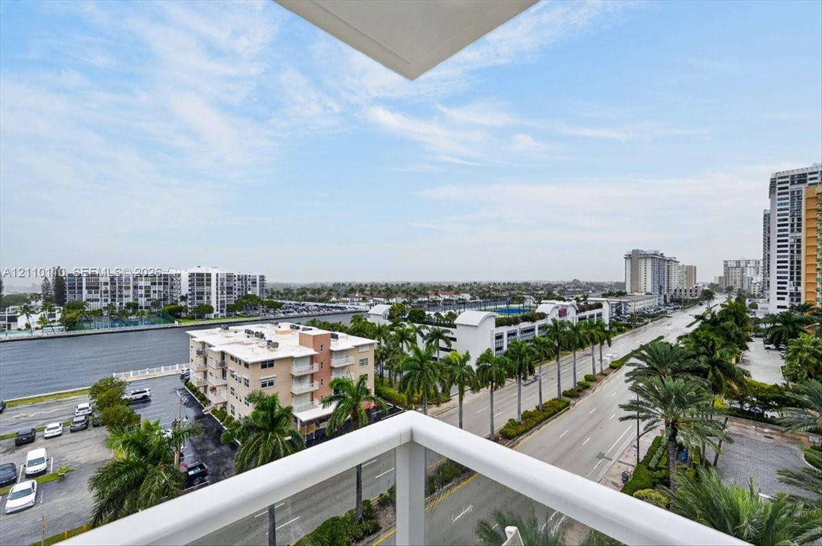 Private balcony featuring white metal railings and expansive city and water surroundings