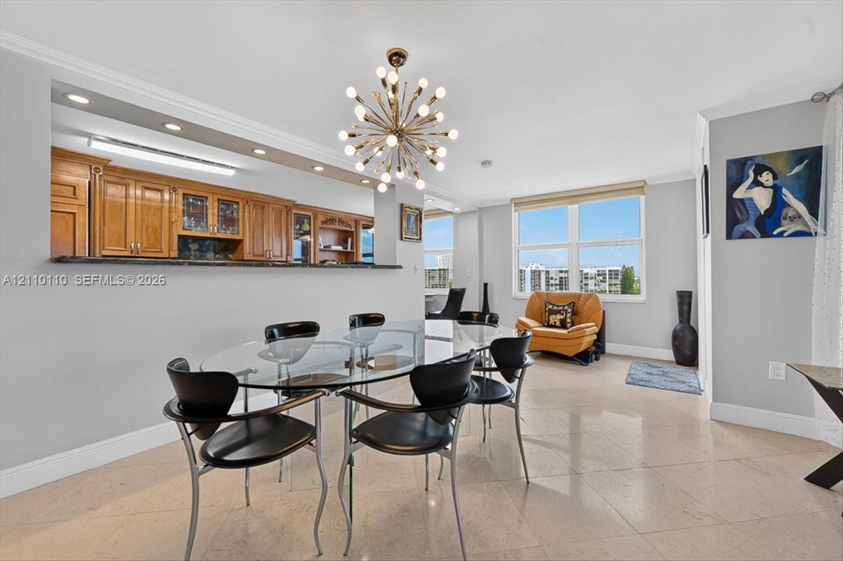 Open-concept dining area featuring stone flooring, a multi-light starburst chandelier, and recessed lighting