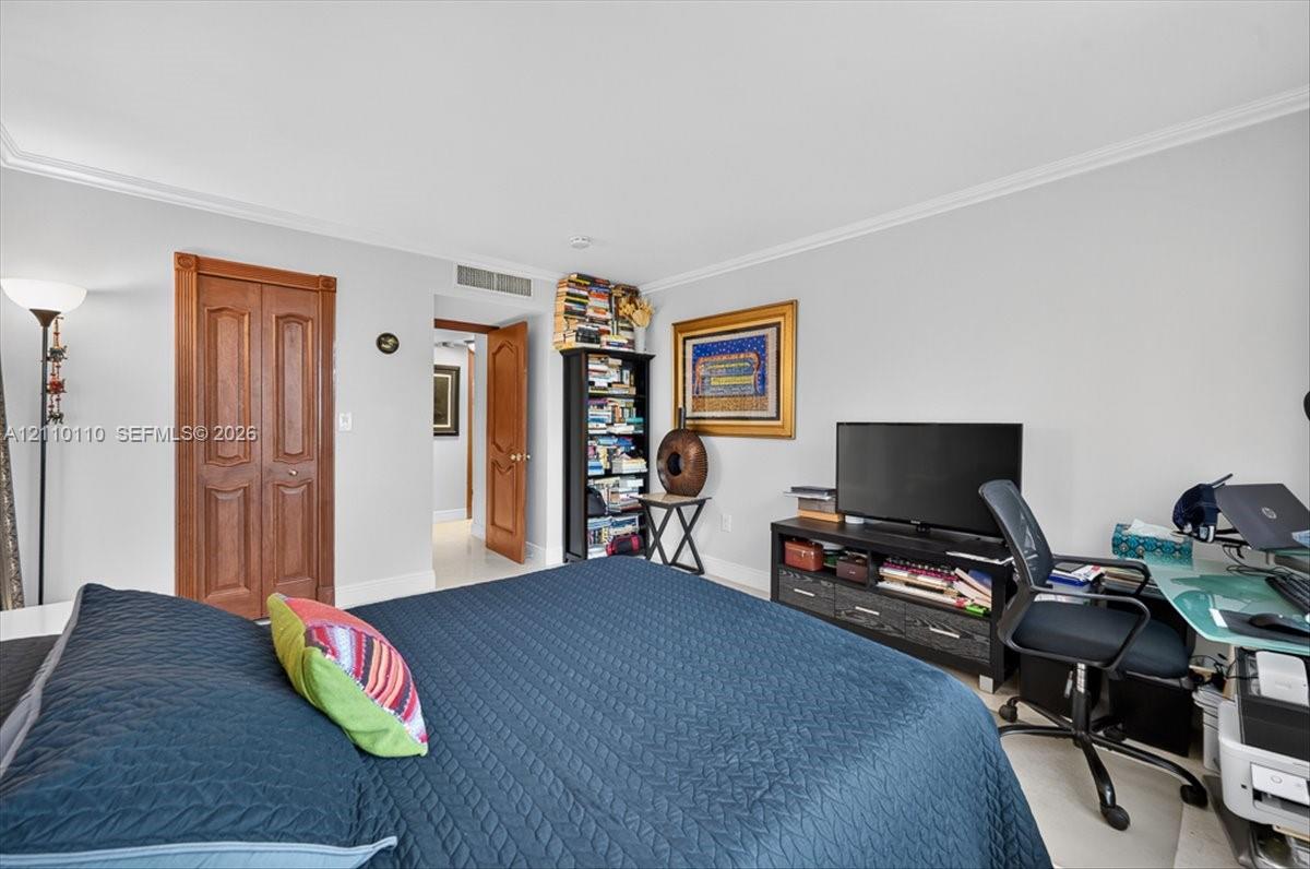 Neutral wall tones, crown molding, and wood-finish interior doors
