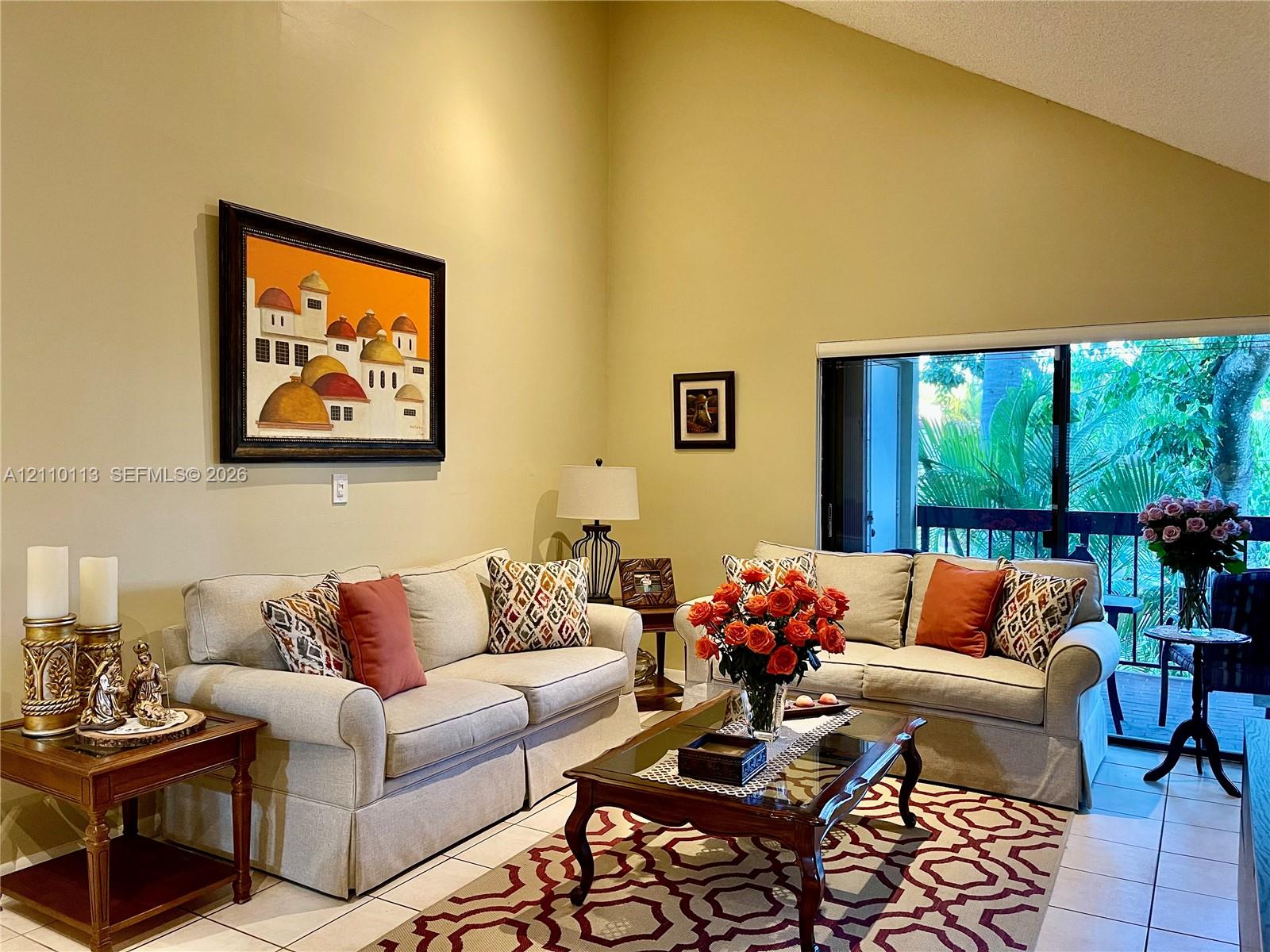 High vaulted ceiling, tile flooring, and oversized sliding glass doors High vaulted ceiling, tile flooring, and oversized sliding glass doors