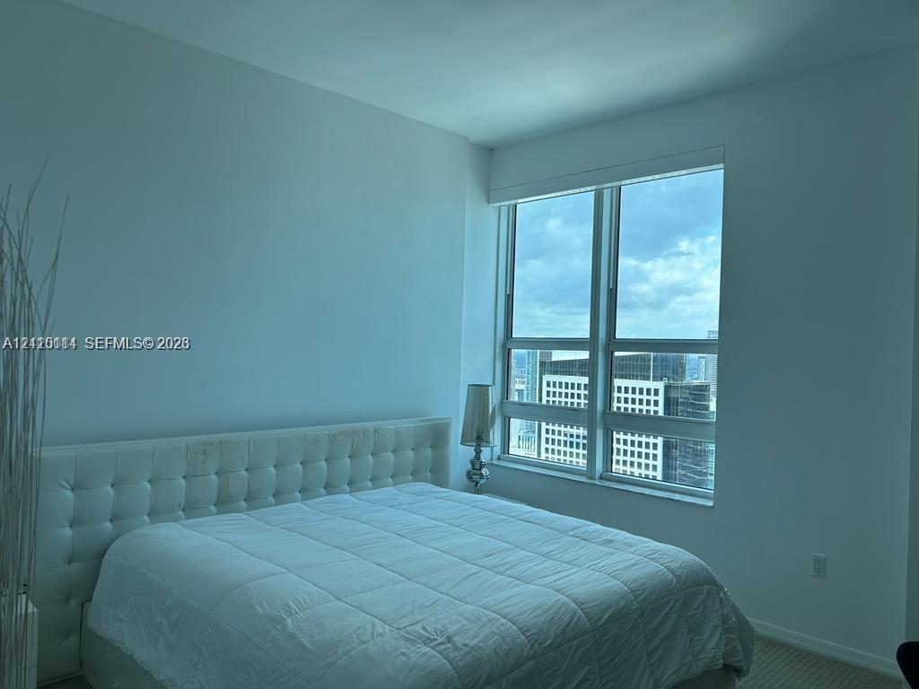 Floor-to-ceiling windows with expansive glass panels and neutral carpeting