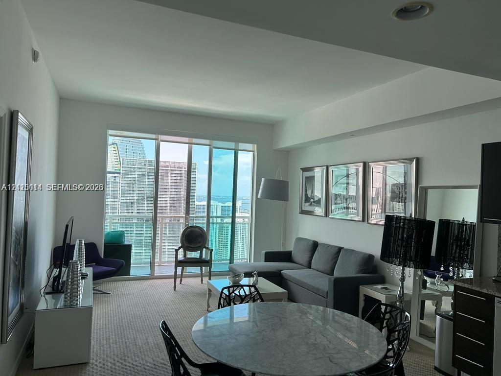 Floor-to-ceiling sliding glass doors, recessed lighting, and wall-to-wall carpeting