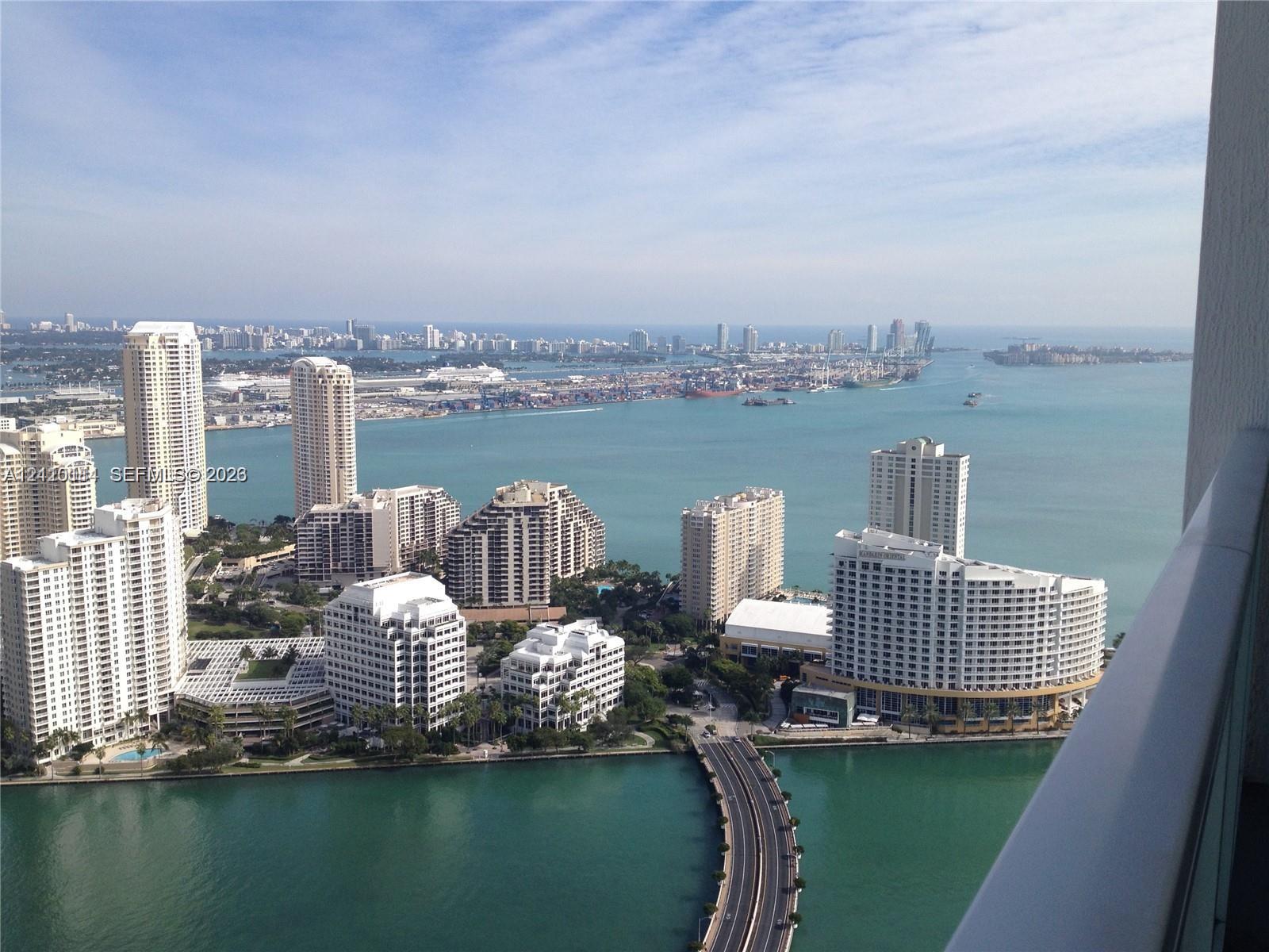 Elevated balcony featuring a metal railing and a panoramic coastal and cityscape backdrop