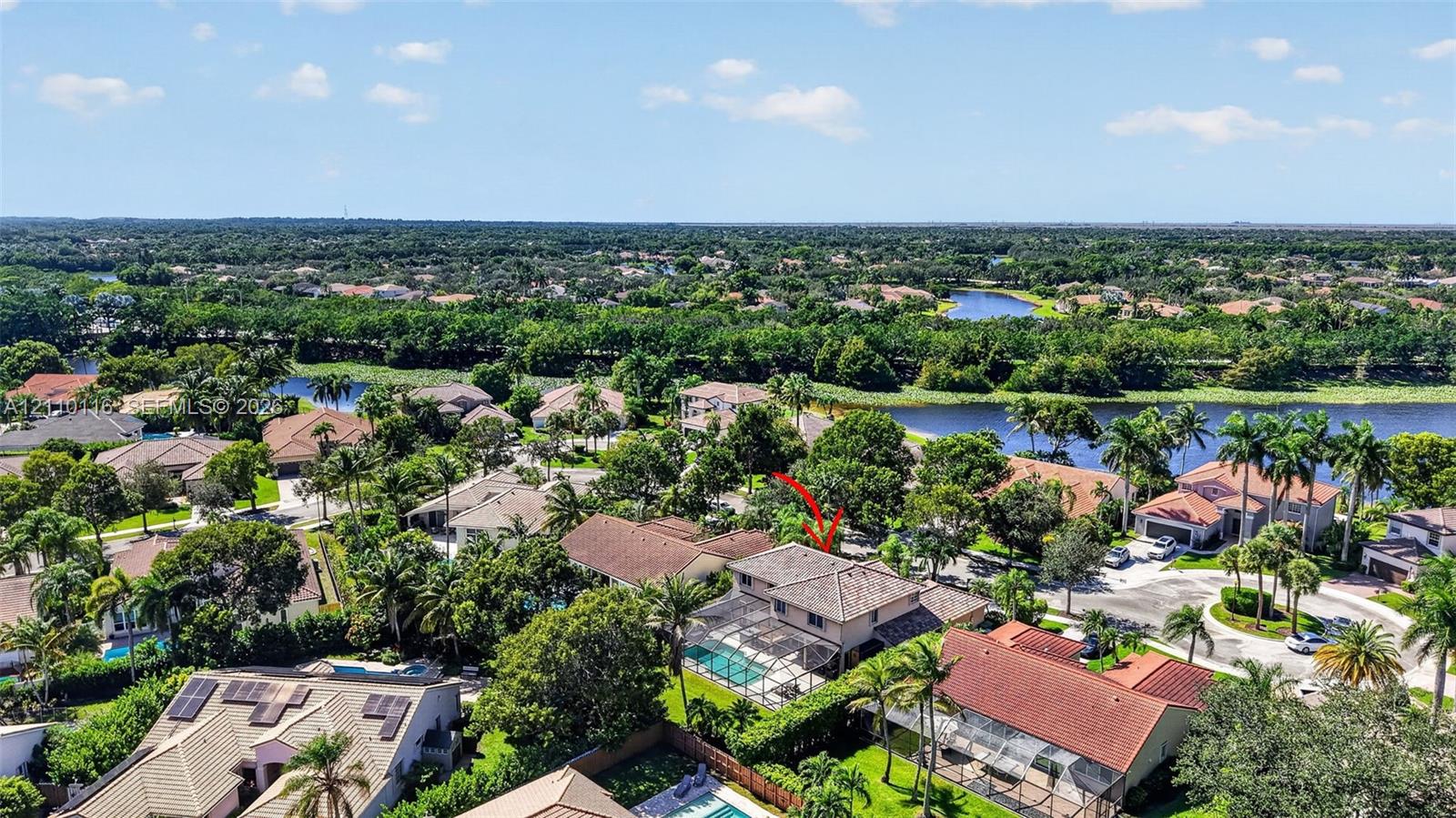 Two-story residence featuring a tile roof, an enclosed swimming pool, and a private rear yard with mature landscaping